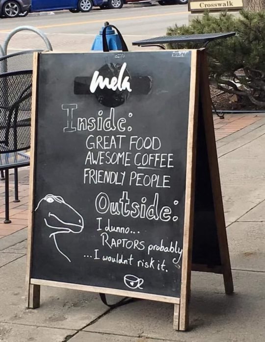This cafe's sign is hilarious - they're more scared of raptors outside than their delicious coffee and food inside.