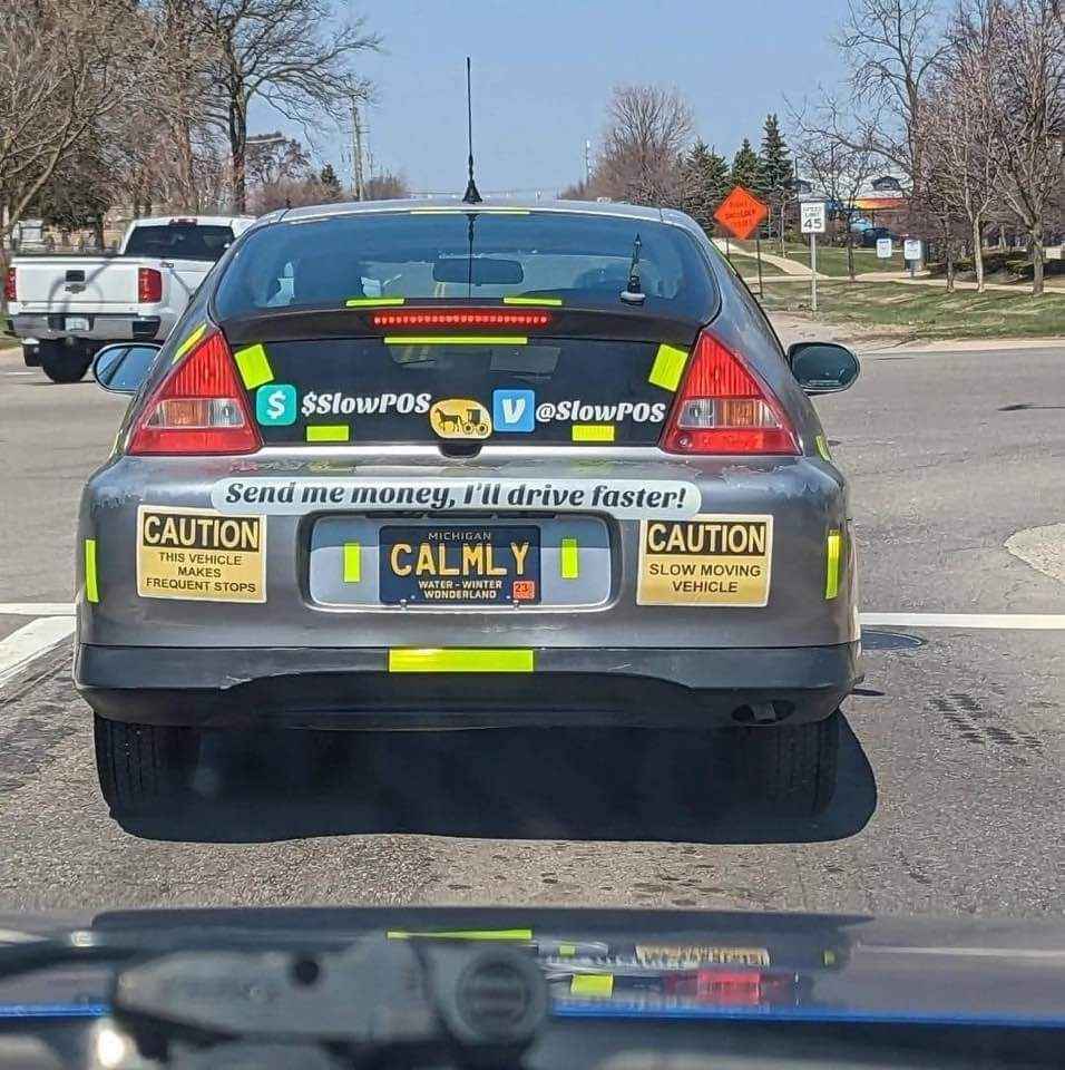This car owner is basically saying 'pay me to not be a slowpoke' with all these stickers.  The 'Calmly' license plate really ties it all together.