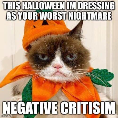 Grumpy Cat dressed as a pumpkin, declaring they'll be negative criticism for Halloween lol